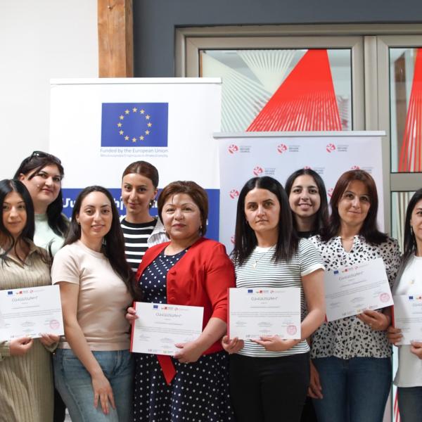 People standing with diplomas 